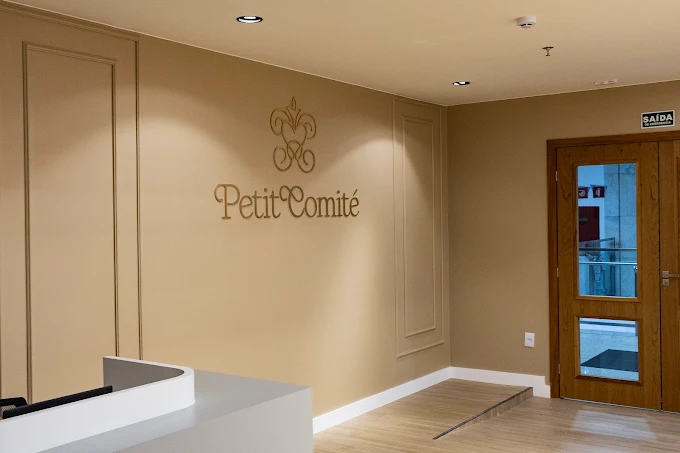 Recepção com a logo Petit Comité na parede