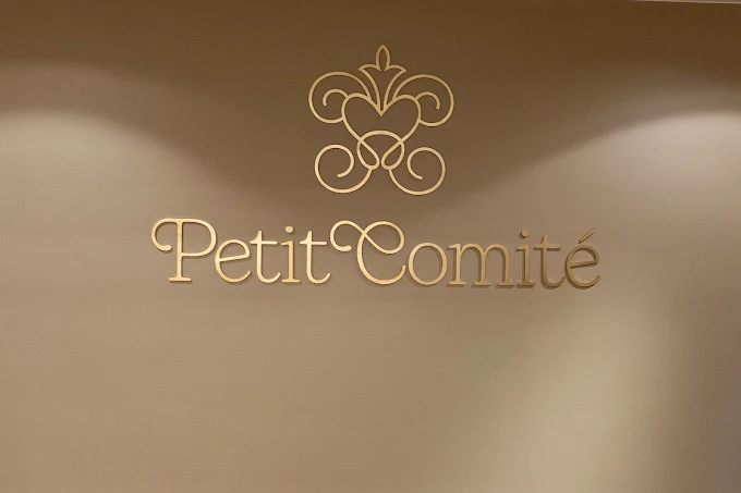 Logo Petit Comité em detalhe dourado na parede